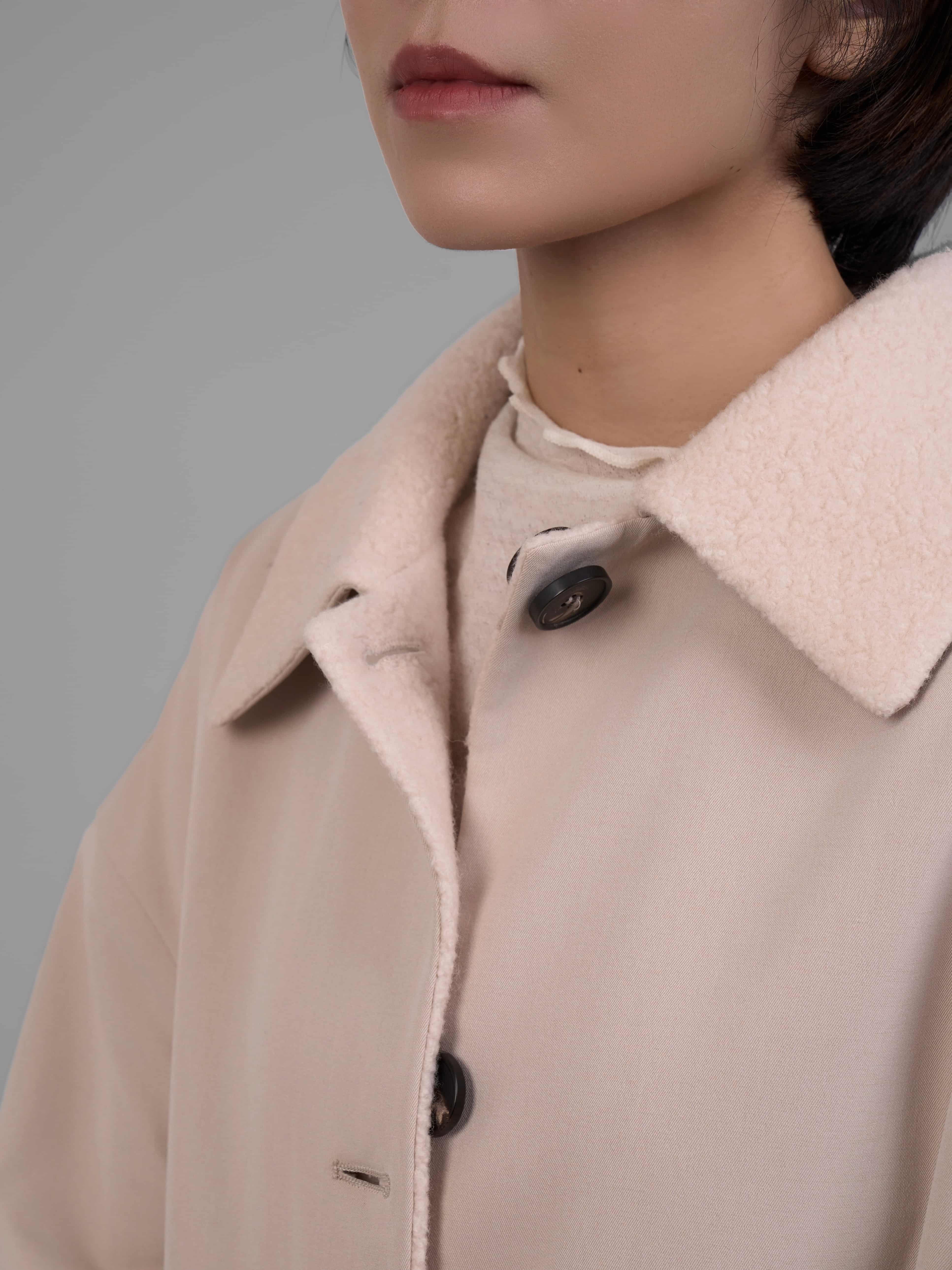 Close-up of the reversible wool coat collar in cream, showing clean finish and inner texture.