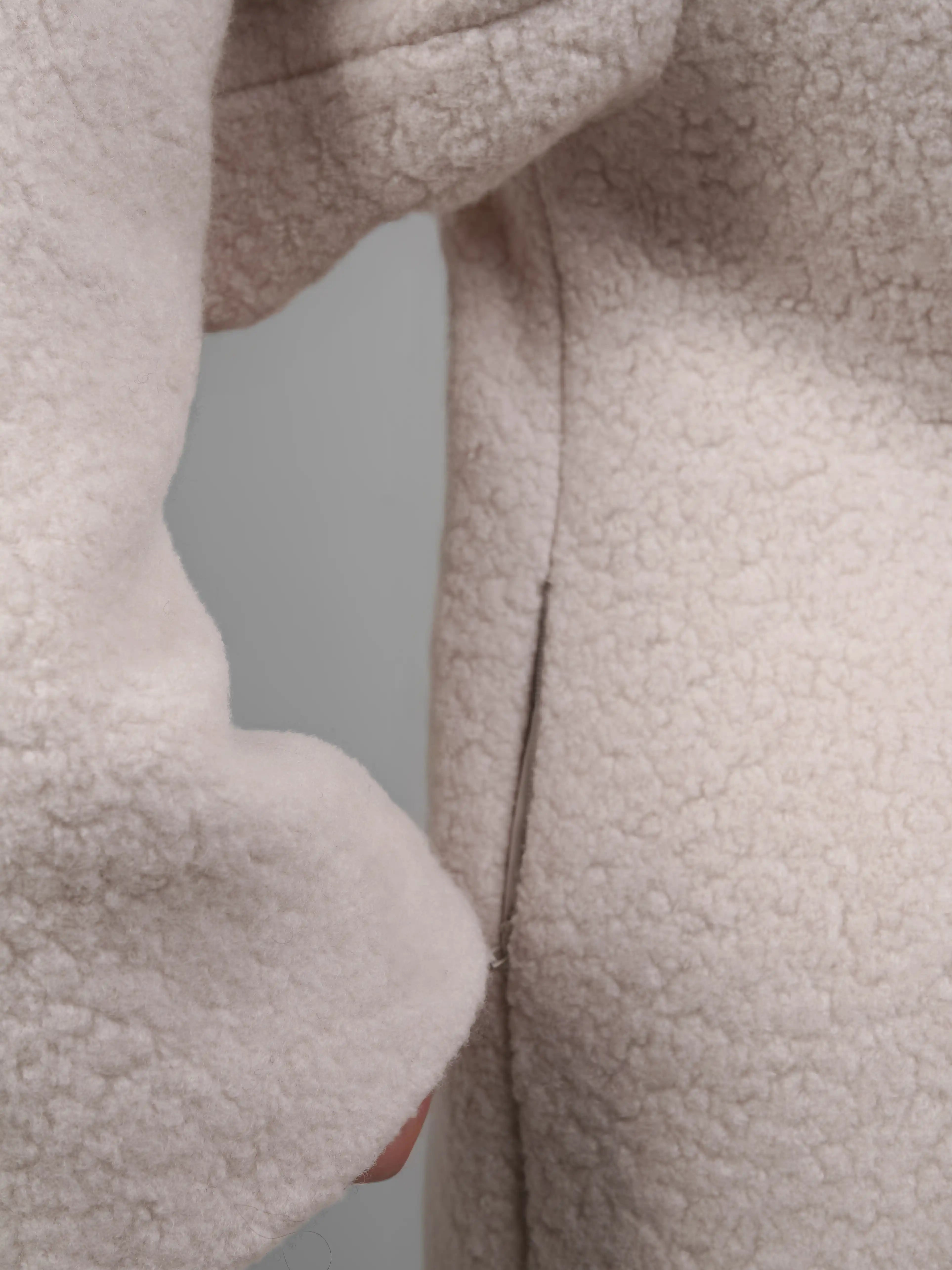 Close up sleeve cuff texture of XXLsmile reversible wool coat in cream showing plush wool finish