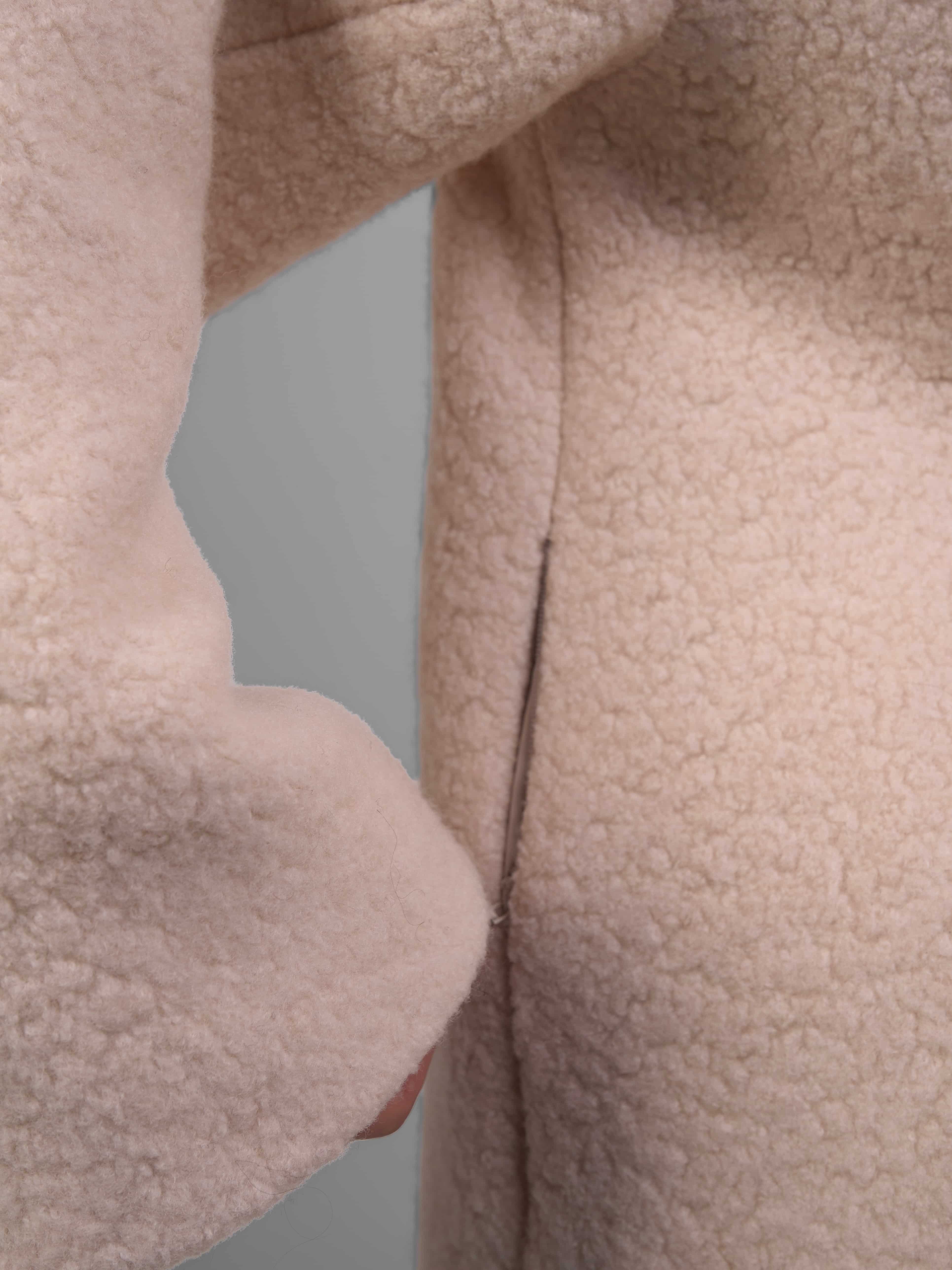 Detail shot of reversible wool coat inner side, highlighting contrasting smooth texture.