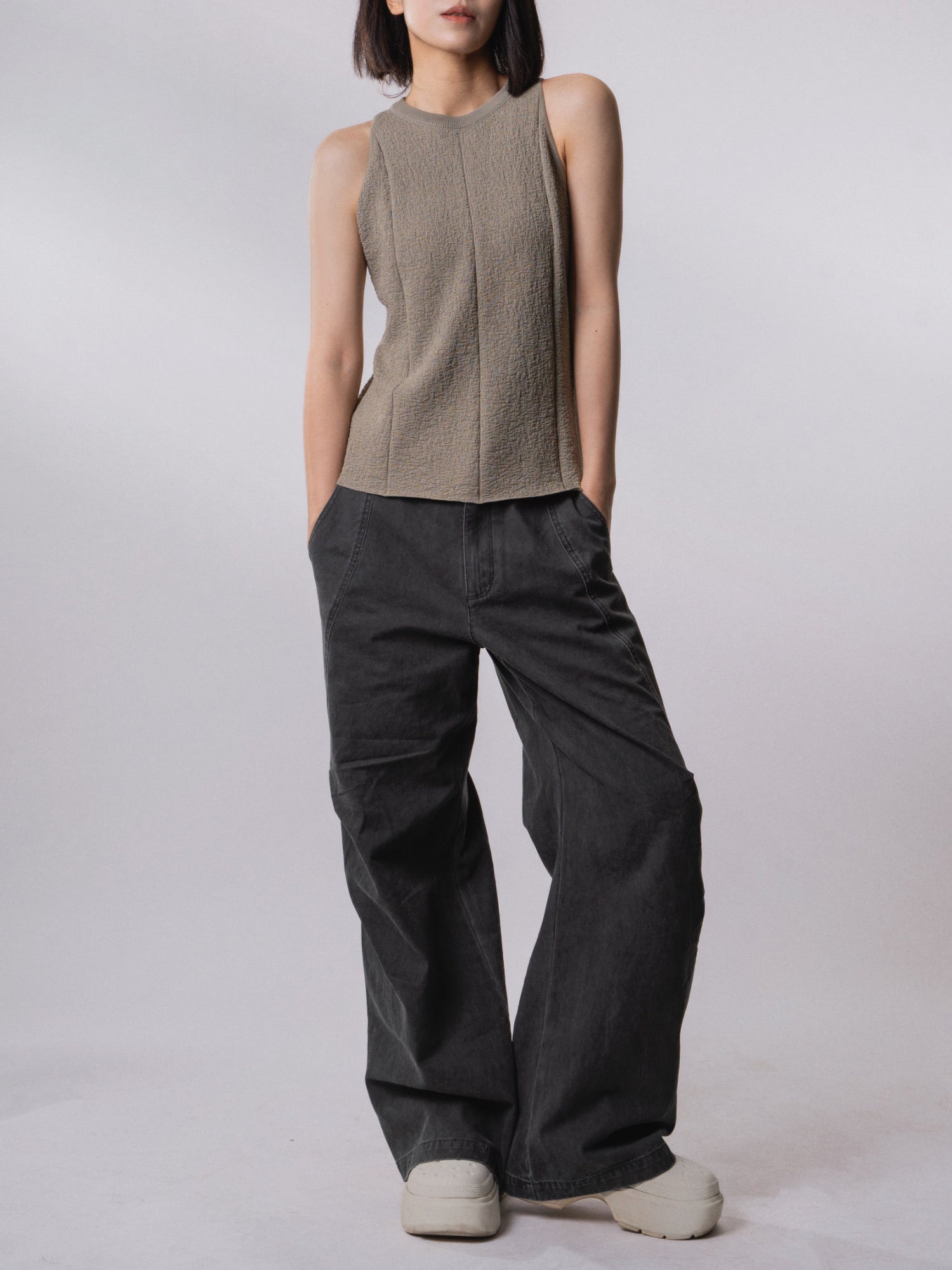 Model wearing the Textured Knit Shell in Muted Sage with relaxed wide-leg trousers.