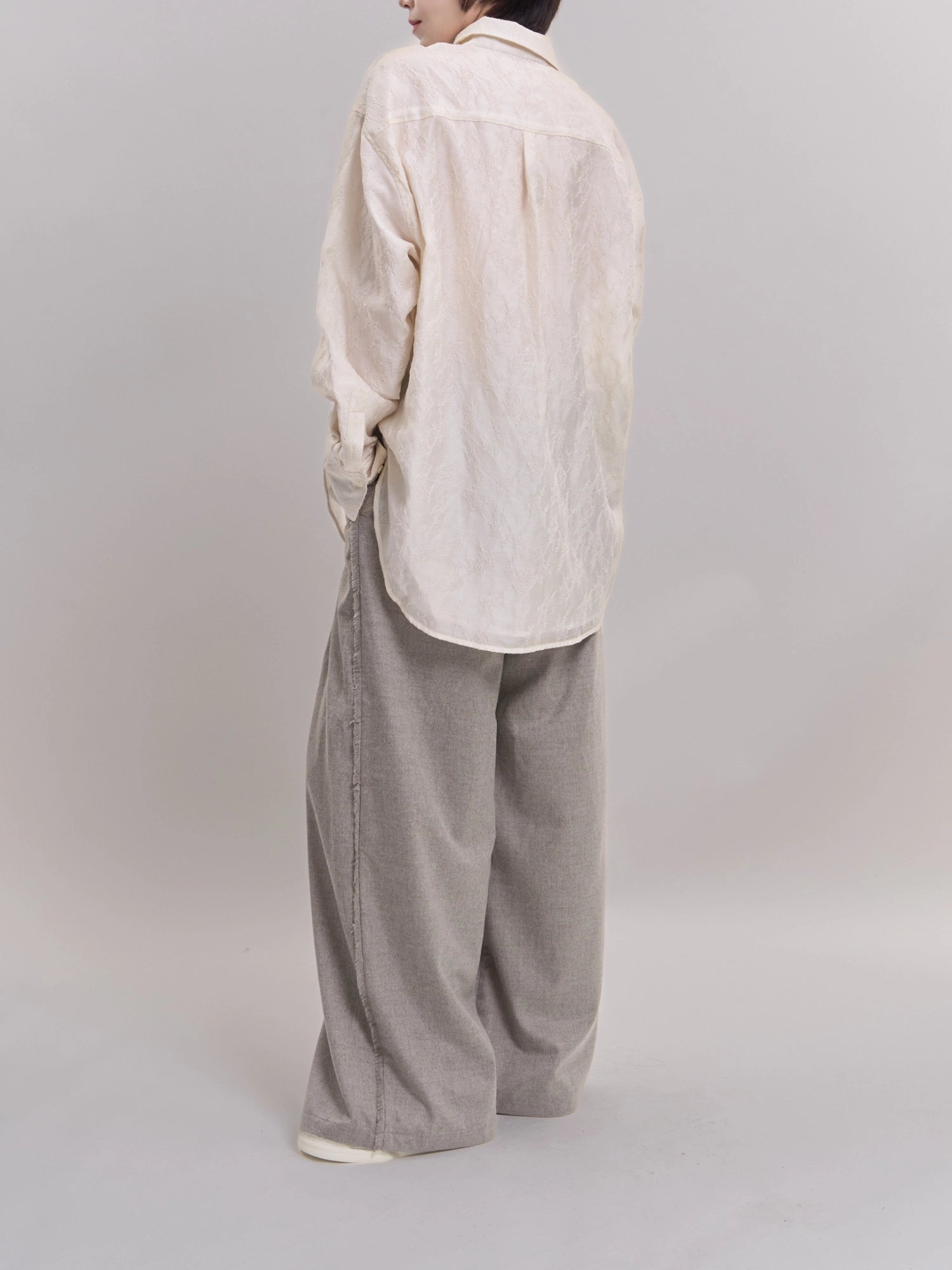 Back view of white Textured Shirt highlighting cocoon silhouette and rounded hem.