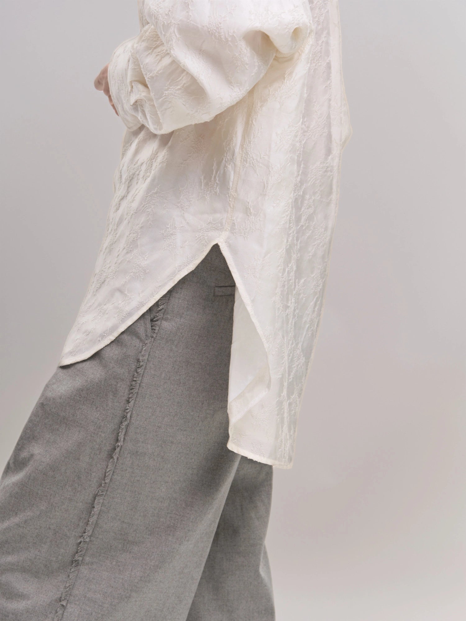Side view of white Textured Shirt showing curved hemline and lightweight, breathable structure.