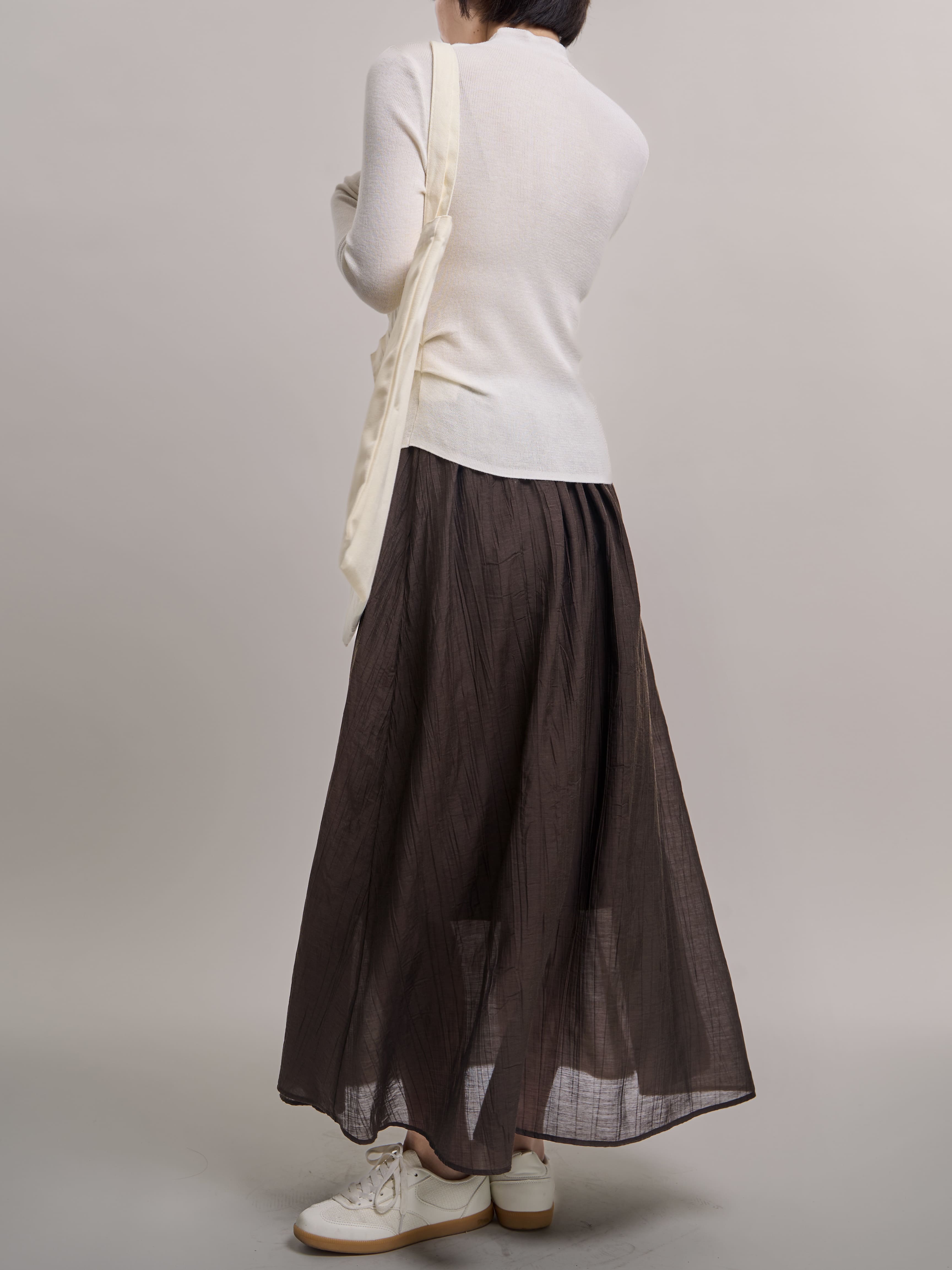 Back view of Veil Pleats Skirt showing lightweight pleats and sheer layered hemline.