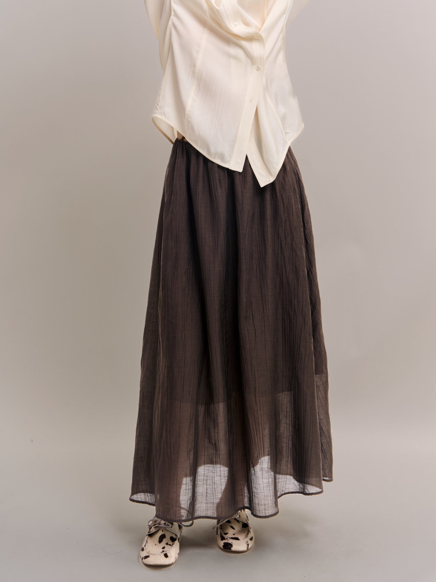 Front view of dark brown Veil Pleats Skirt showing fine pleats, lightweight structure and soft drape.