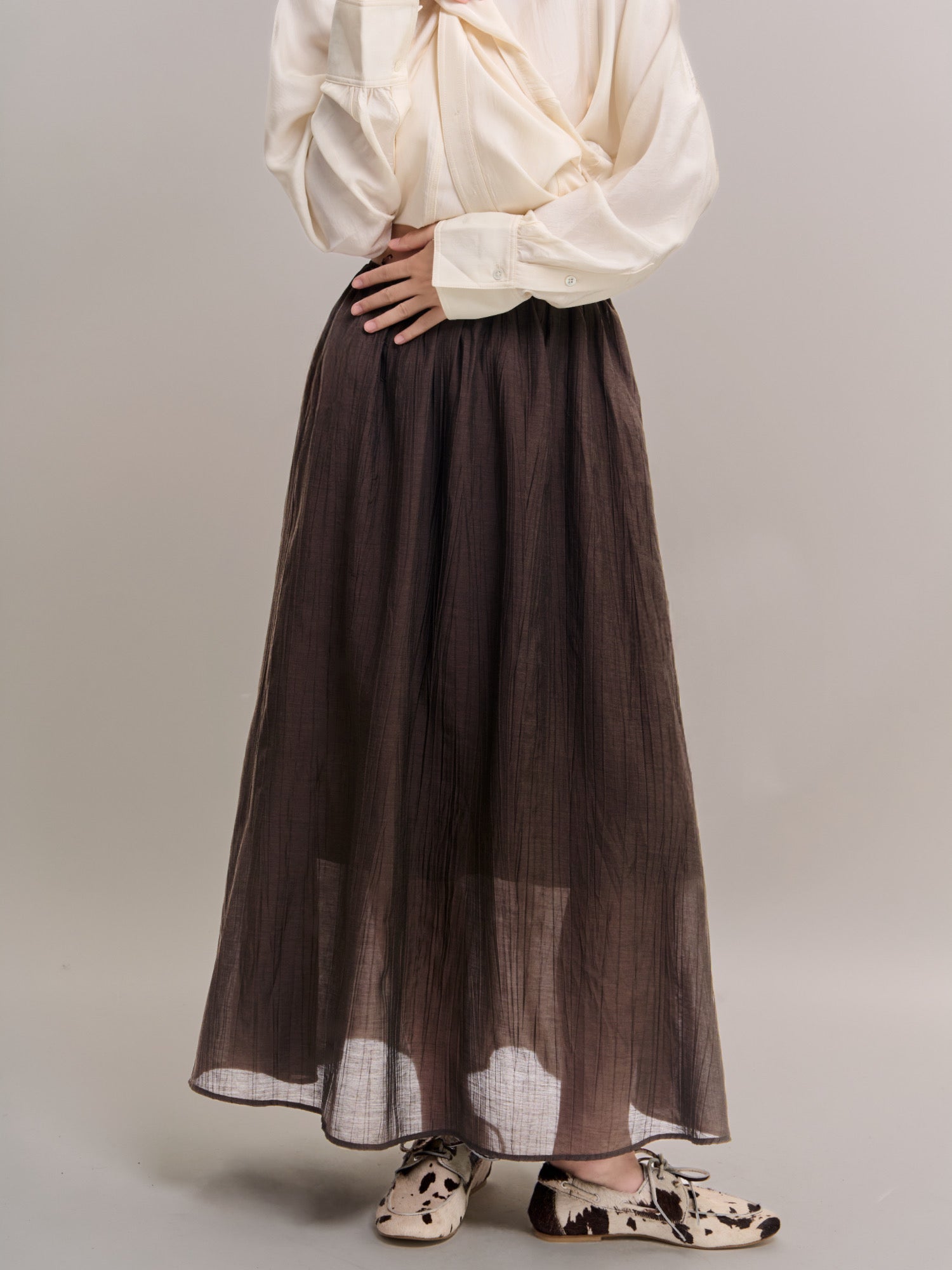 Front angled view of Veil Pleats Skirt highlighting sheer hem and clean vertical pleats.