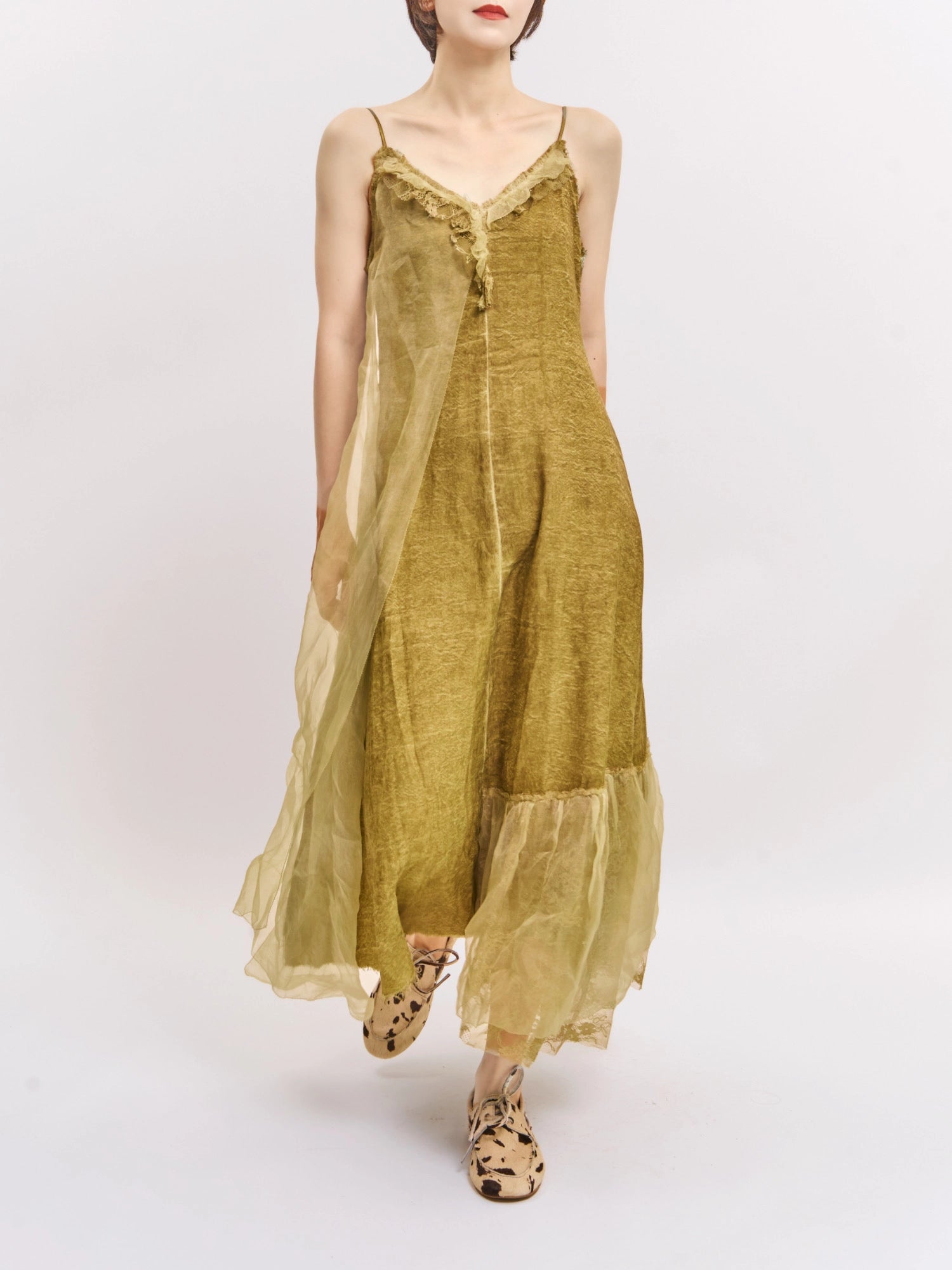 Model wearing olive Verdant Veil Dress with mulberry silk overlay, full-body studio shot showing flowing asymmetric hem.