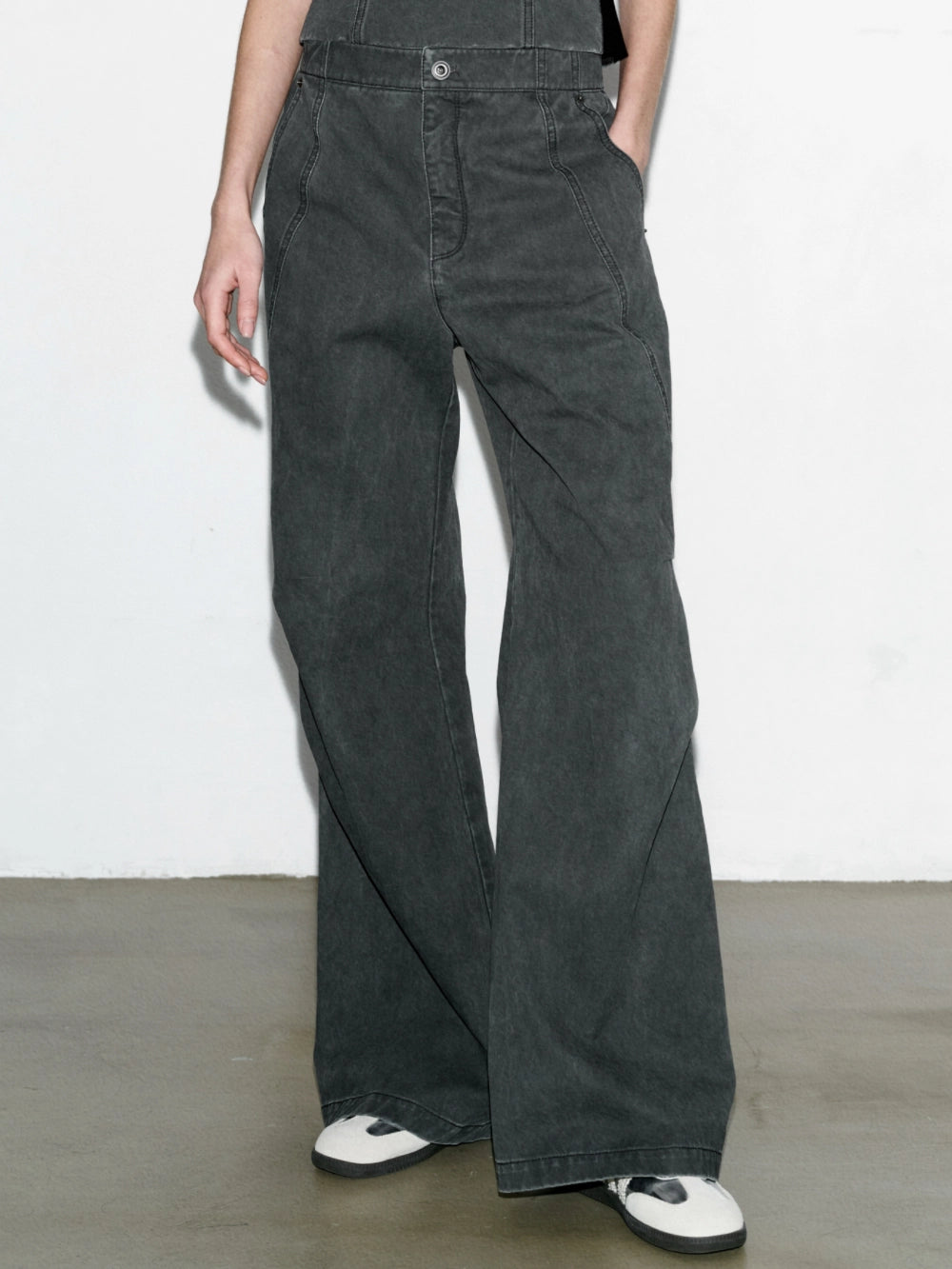 Front view of washed paratrooper jeans, hands in pockets, clean wide silhouette with washed cotton texture.