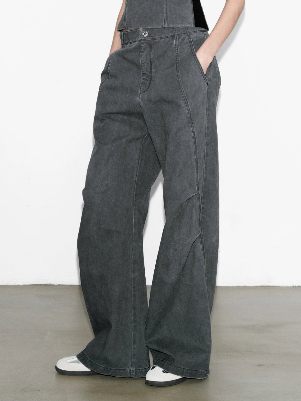 Side view of charcoal washed paratrooper pants showing knee folds and curved panel structure.