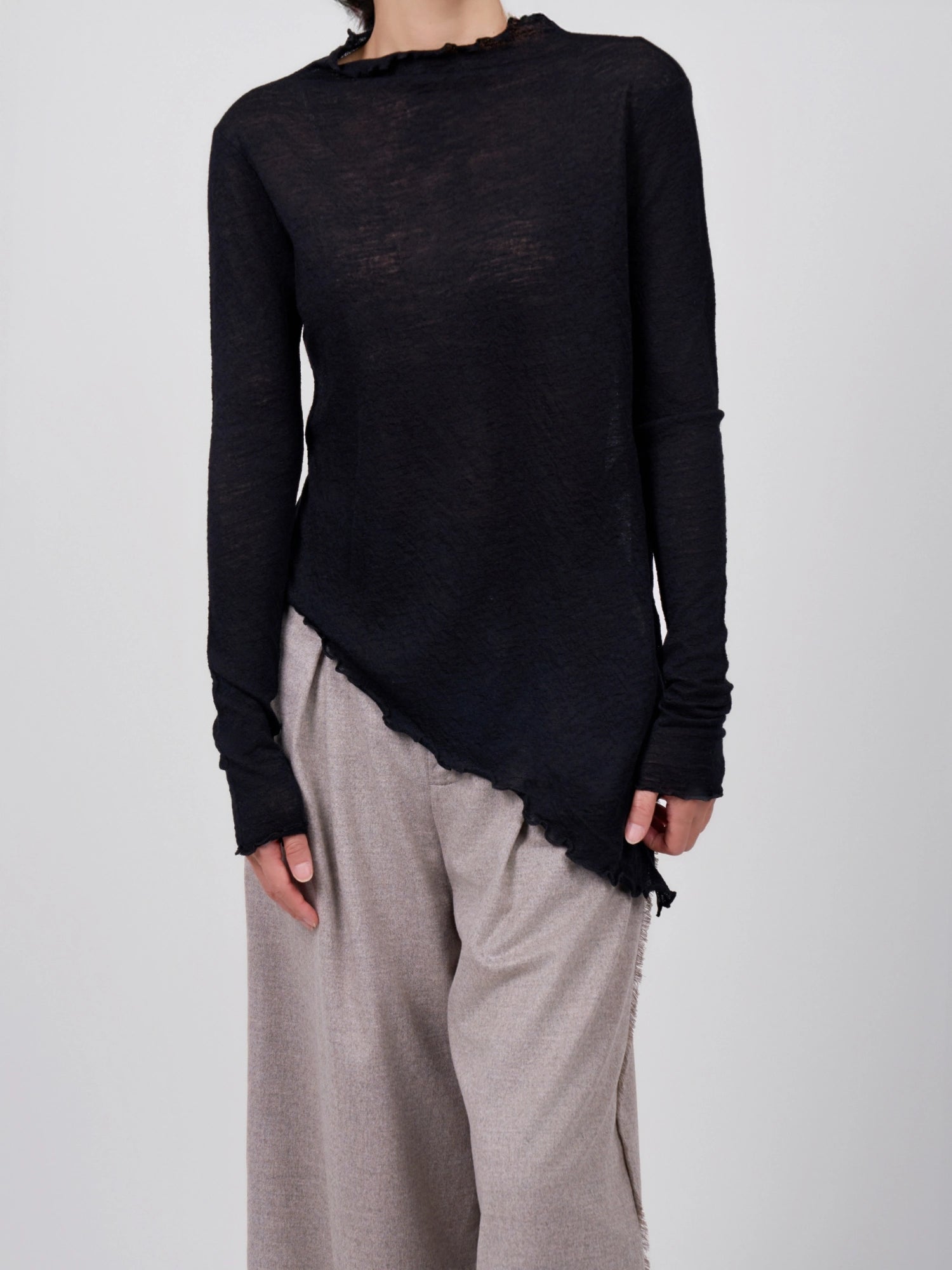 Full-body front shot of black wool base layer styled for everyday layering, asymmetric hem in clear view.