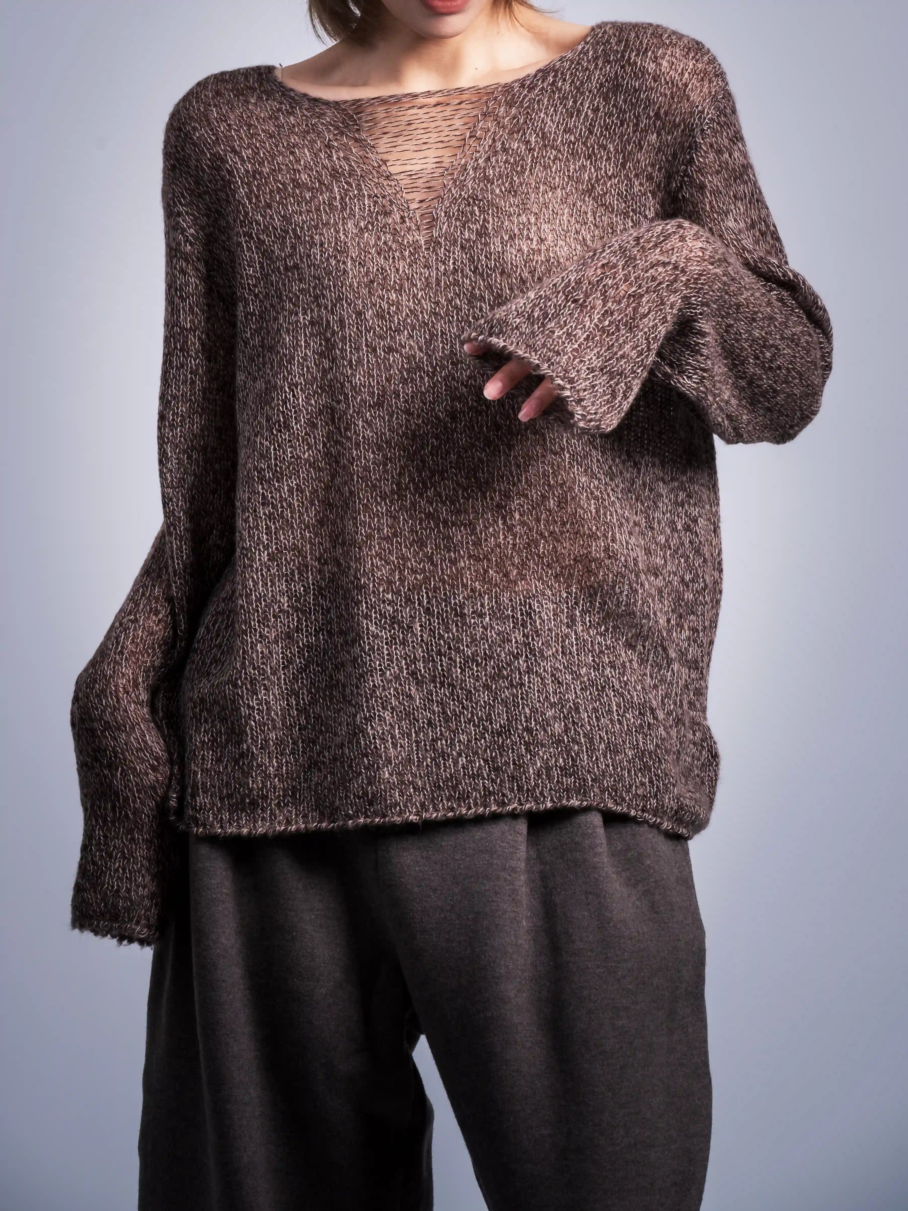Close-up of wool jumper texture, soft halo yarn surface, sleeve length shown with natural drape.