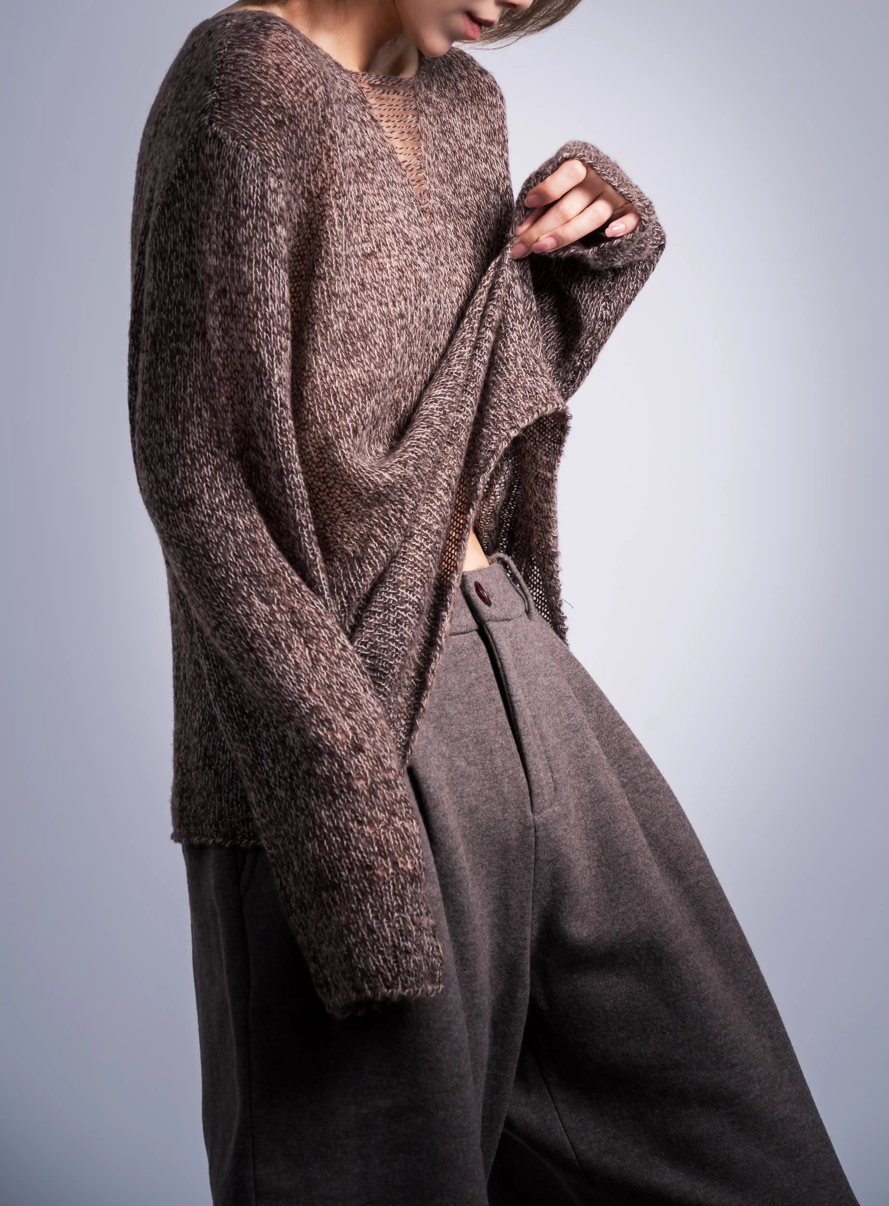 Side view of loose wool jumper, long sleeves and French-casual silhouette, soft volume around the body.