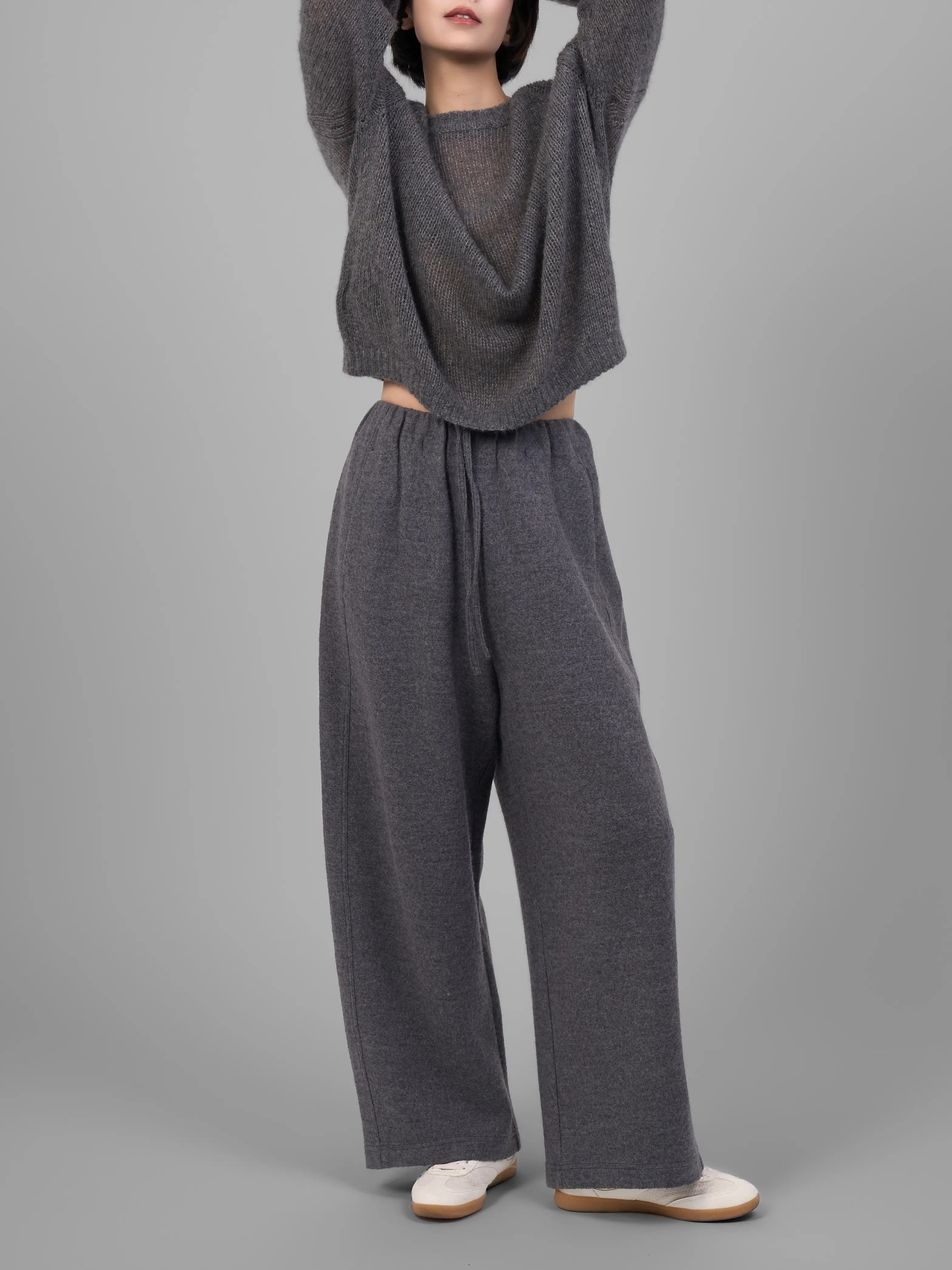 Grey wool-blend knit trousers front view, styled with knit top, studio lighting.
