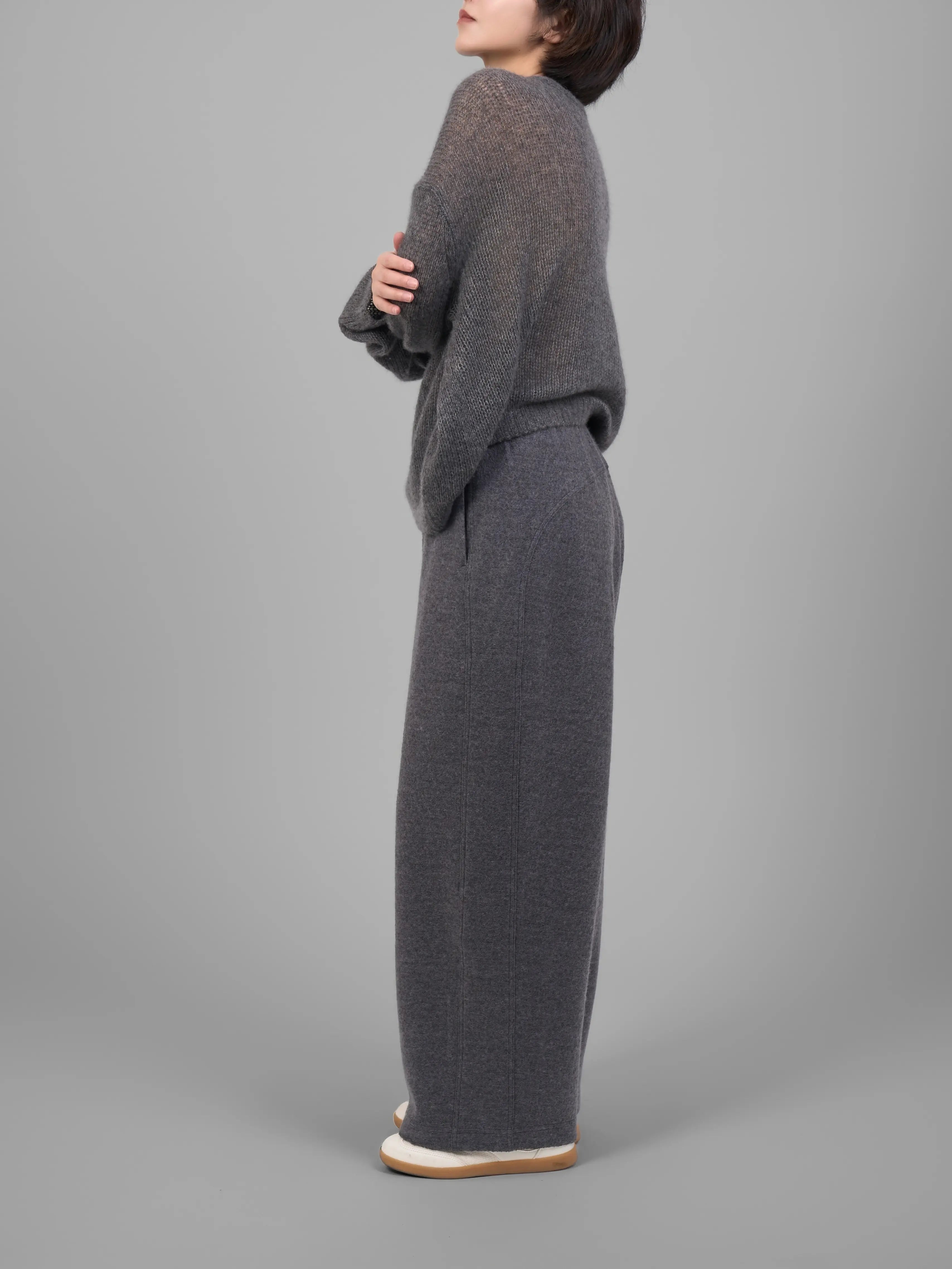 Grey wool-blend knit trousers side view showing straight-leg silhouette.