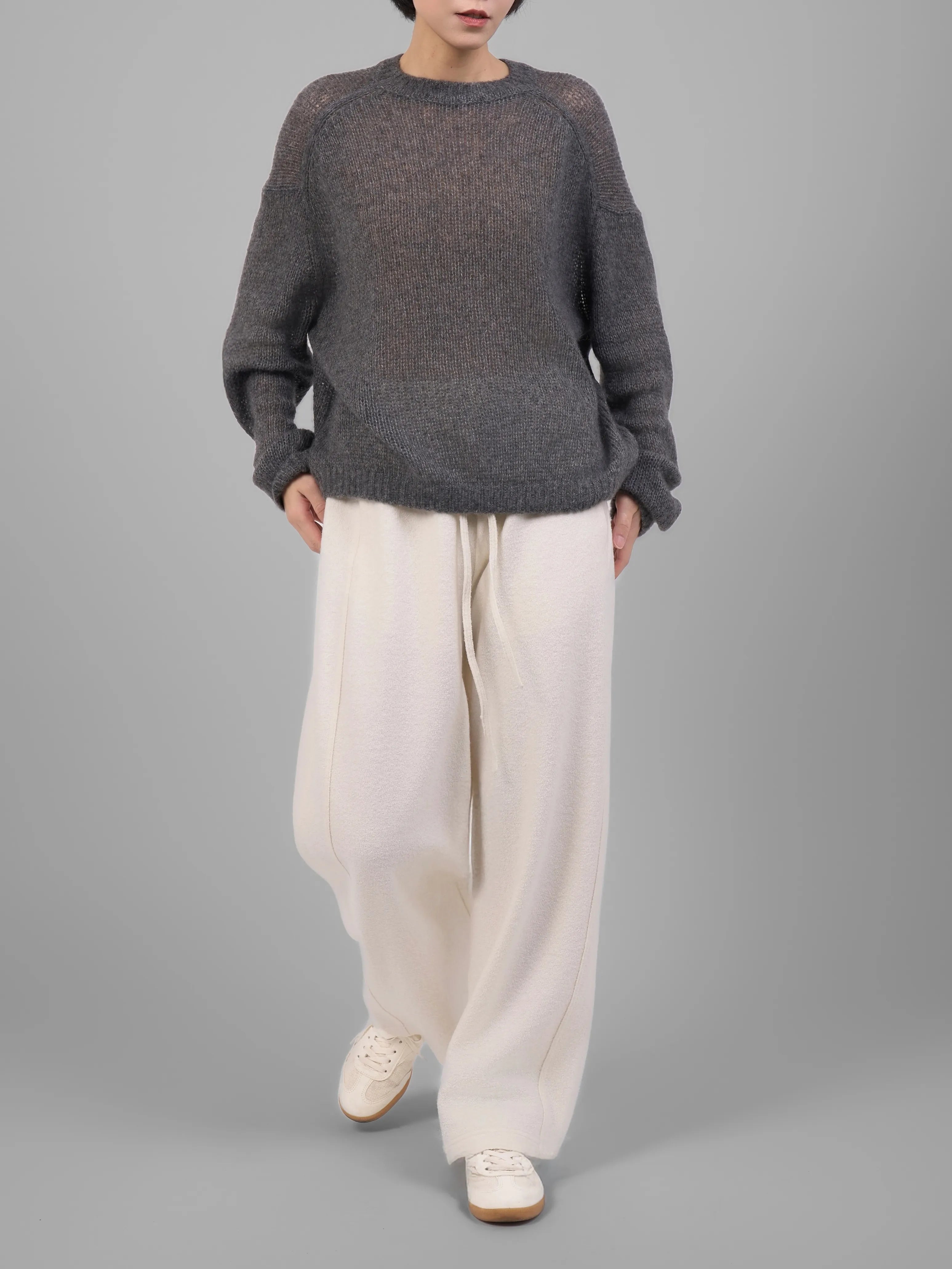 Grey wool-blend knit trousers styled with white trousers outfit, front studio look.