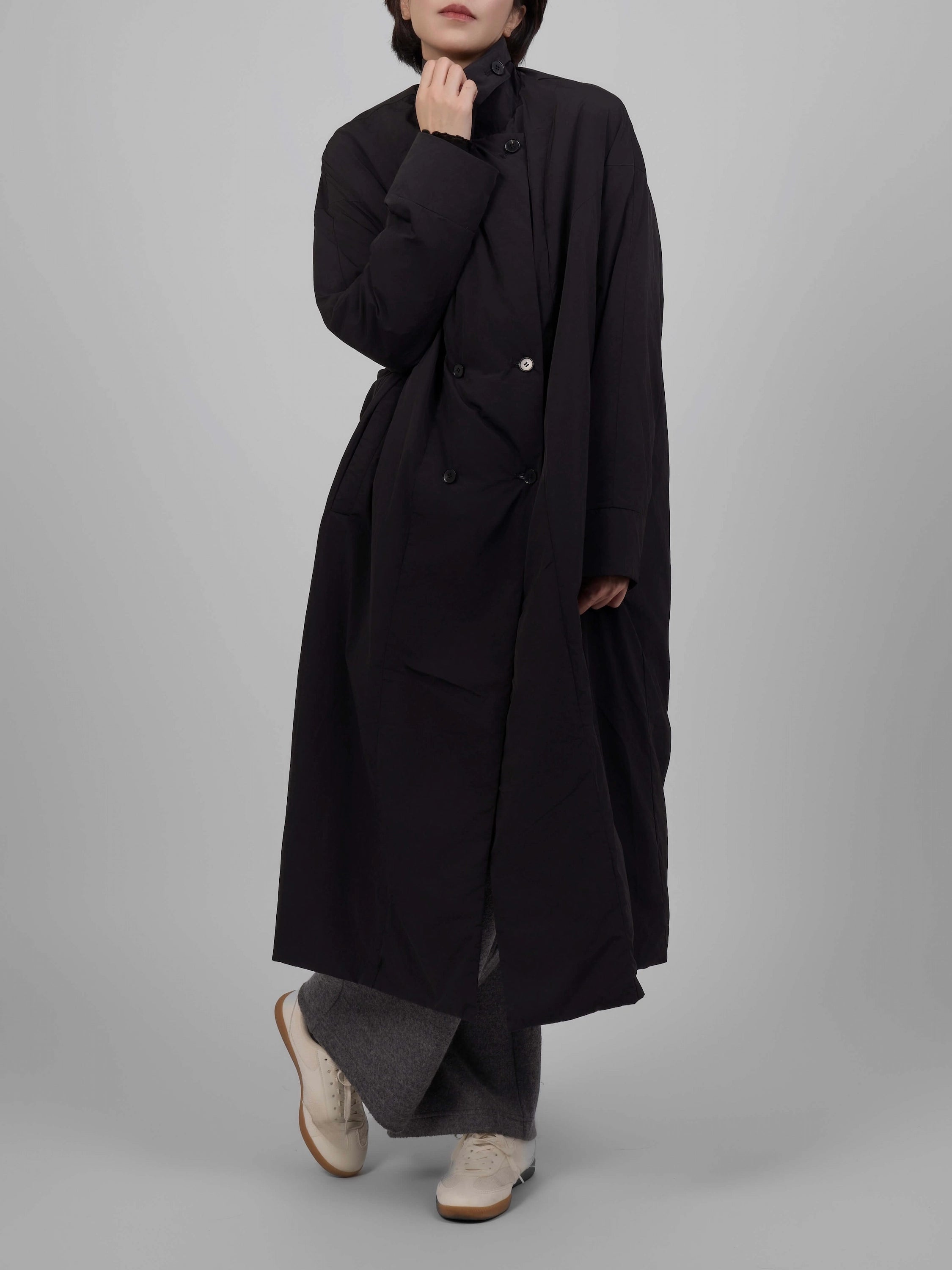 Black oversized down coat displayed at a half-side angle, hands together.